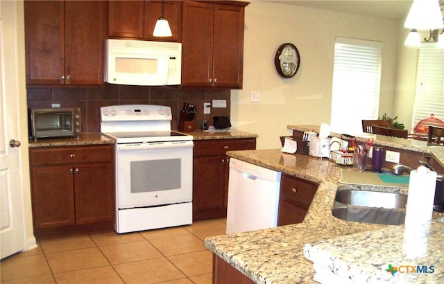 kitchen with light tile patterned flooring, sink, tasteful backsplash, decorative light fixtures, and white appliances