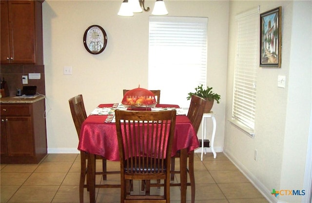 dining room with light tile patterned flooring and a chandelier