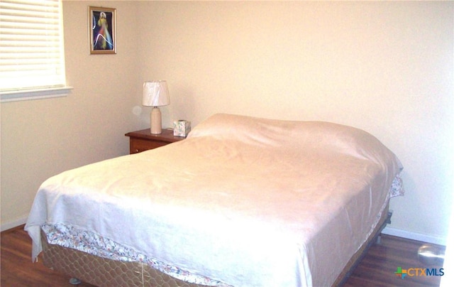 bedroom with dark wood-type flooring