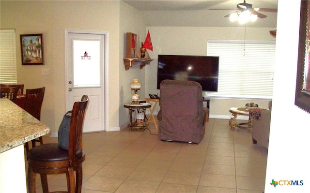 interior space with light tile patterned flooring, plenty of natural light, and ceiling fan