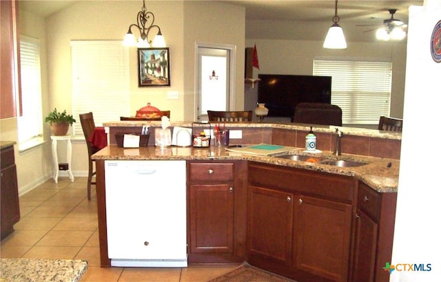 kitchen featuring white dishwasher, hanging light fixtures, light tile patterned floors, and sink