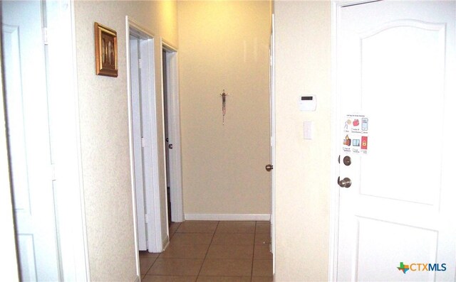 hall with dark tile patterned floors