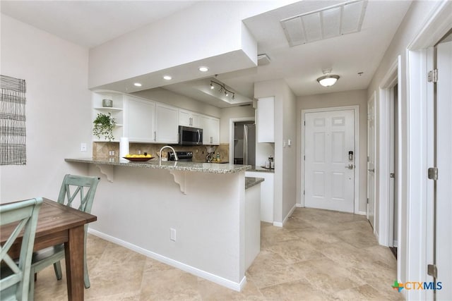 3404 American Dr Unit 3315, Lago Vista, TX 78645 - kitchen with stainless steel microwave, a peninsula, open shelves, light stone countertops, and visible vents