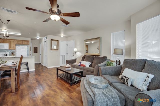 living room with dark hardwood / wood-style flooring and ceiling fan