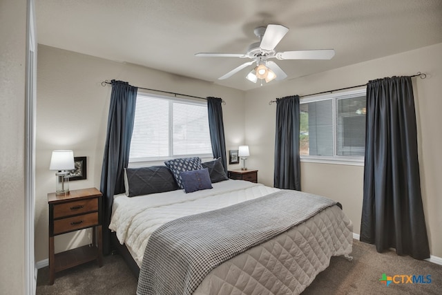 carpeted bedroom featuring multiple windows and ceiling fan