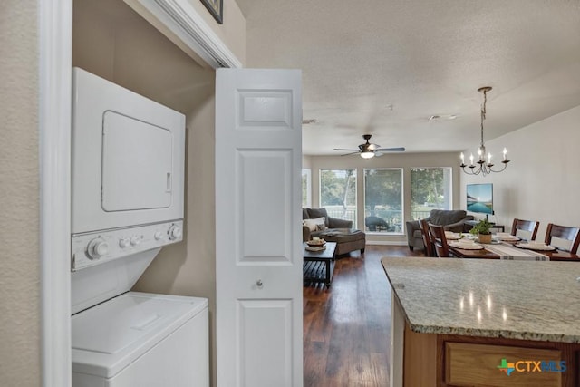 730 E Mather St Unit B101, New Braunfels, TX 78130 - laundry room with stacked washer and clothes dryer, dark wood finished floors, a ceiling fan, a chandelier, and a textured ceiling