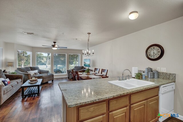 kitchen with dark wood-type flooring, sink, hanging light fixtures, a textured ceiling, and dishwasher