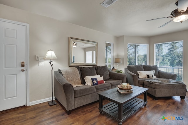 living room featuring ceiling fan and dark hardwood / wood-style flooring