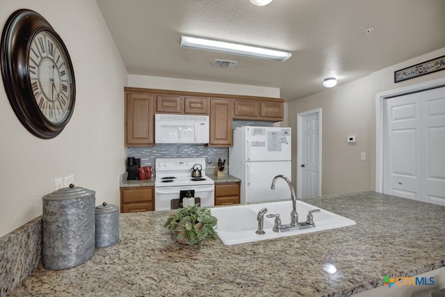 kitchen featuring sink, backsplash, a textured ceiling, and white appliances