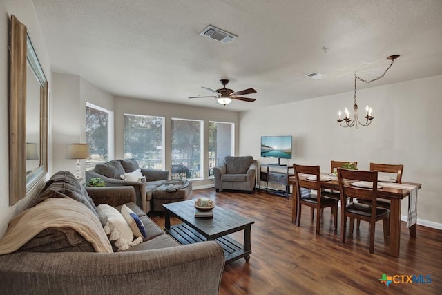 living room featuring ceiling fan with notable chandelier, a textured ceiling, and dark hardwood / wood-style flooring