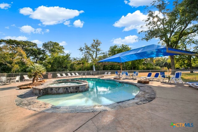 view of swimming pool featuring a patio and an in ground hot tub