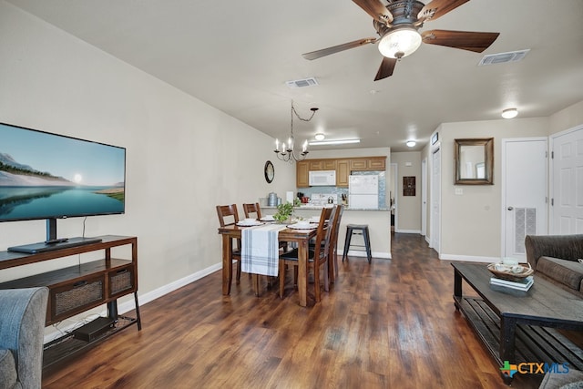 dining room featuring ceiling fan with notable chandelier and dark hardwood / wood-style floors