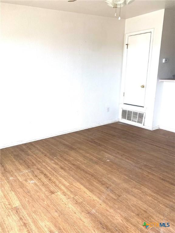 empty room with ceiling fan and light hardwood / wood-style floors