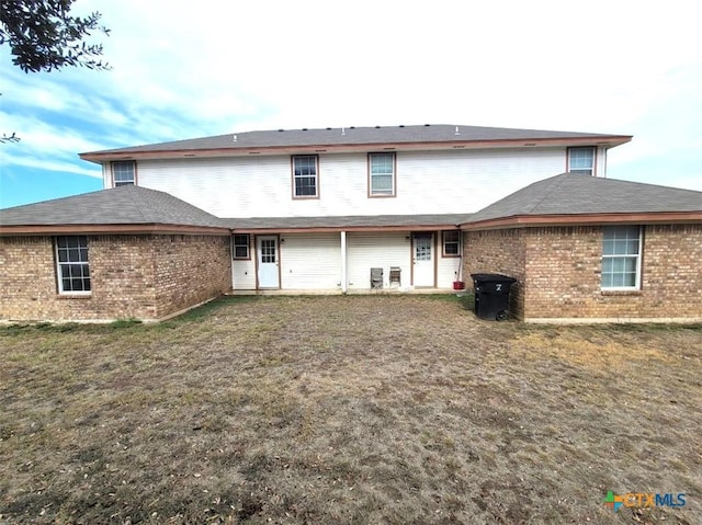 rear view of property featuring a yard