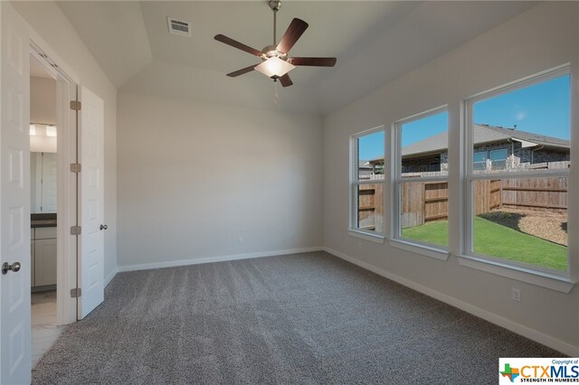 unfurnished room with carpet flooring, ceiling fan, and vaulted ceiling