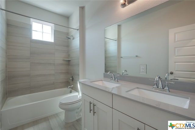 full bathroom with vanity, tiled shower / bath, and toilet