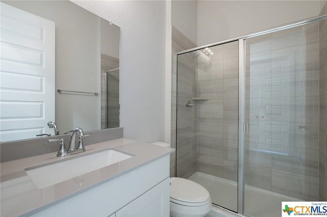 bathroom featuring walk in shower, vanity, and toilet