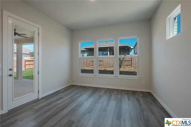 spare room with wood-type flooring, a healthy amount of sunlight, and ceiling fan