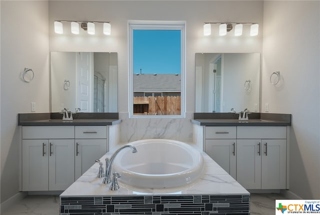 bathroom featuring vanity and tiled bath