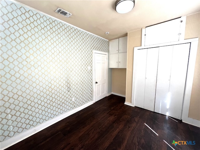 unfurnished bedroom with a closet and dark hardwood / wood-style floors