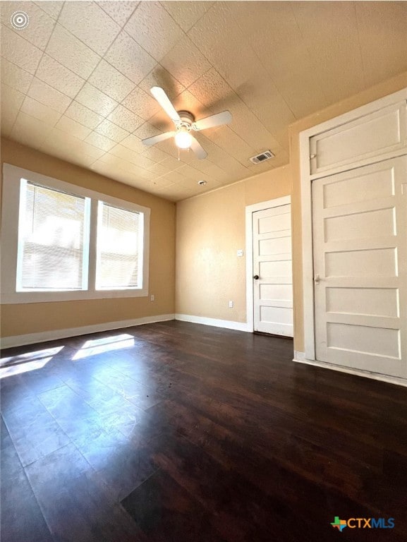 empty room with ceiling fan and dark hardwood / wood-style floors