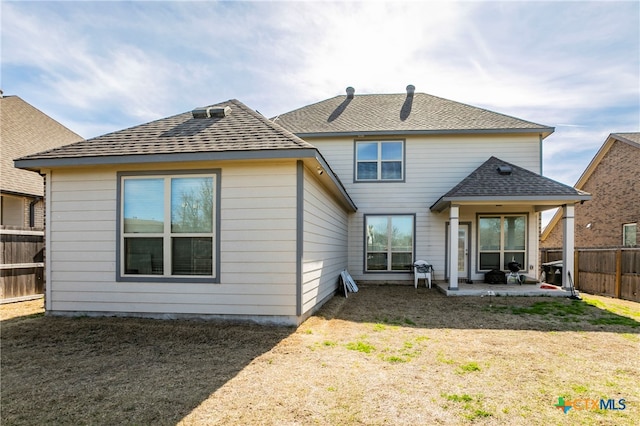 rear view of property with a lawn and a patio