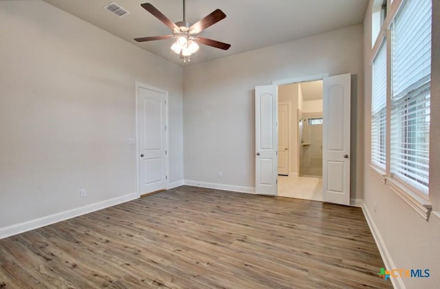 737 Groudsel Ave, New Braunfels, TX 78132 - unfurnished bedroom with wood finished floors, baseboards, and visible vents