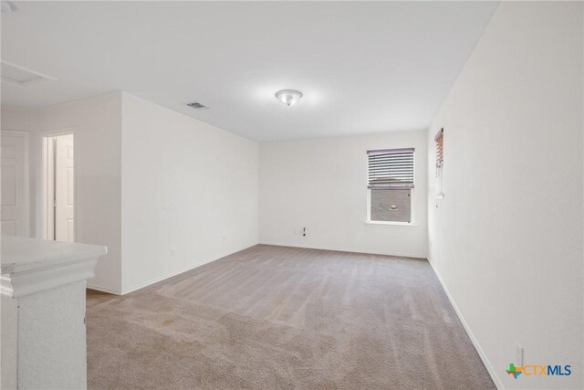 8913 Winter Haven Rd, Austin, TX 78747 - spare room featuring light carpet, baseboards, and attic access