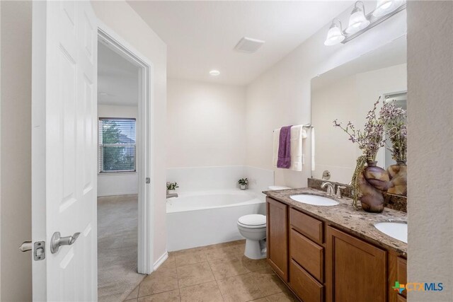 8913 Winter Haven Rd, Austin, TX 78747 - full bath featuring double vanity, a garden tub, tile patterned floors, and toilet