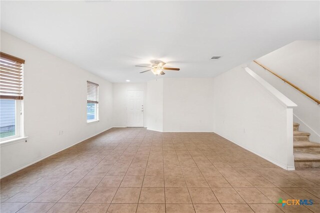 8913 Winter Haven Rd, Austin, TX 78747 - unfurnished living room with ceiling fan, stairs, and light tile patterned flooring