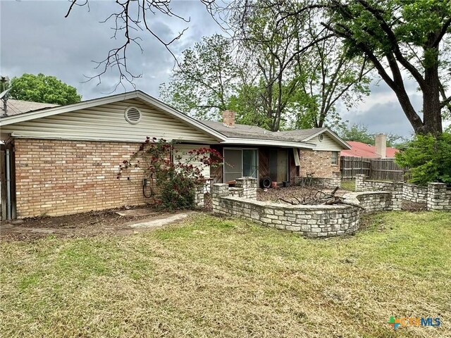 1804 Prather Dr, Killeen, TX 76541 - rear view of property with brick siding, fence, a yard, and a chimney