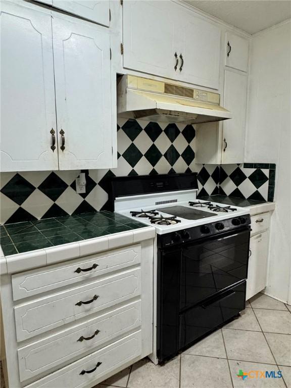 1804 Prather Dr, Killeen, TX 76541 - kitchen with decorative backsplash, white cabinetry, under cabinet range hood, and black gas range oven