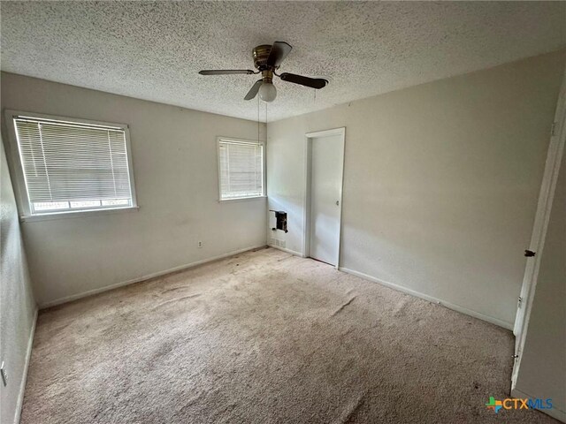 1804 Prather Dr, Killeen, TX 76541 - unfurnished bedroom featuring a textured ceiling, multiple windows, ceiling fan, and carpet