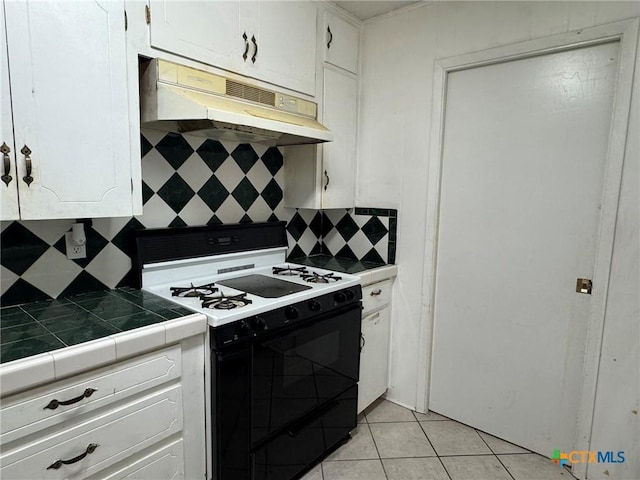 1804 Prather Dr, Killeen, TX 76541 - kitchen featuring white cabinetry, decorative backsplash, light tile patterned floors, gas range, and under cabinet range hood