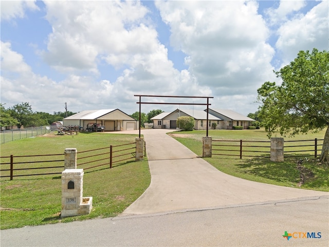 view of front of home with a front lawn, a garage, and a rural view