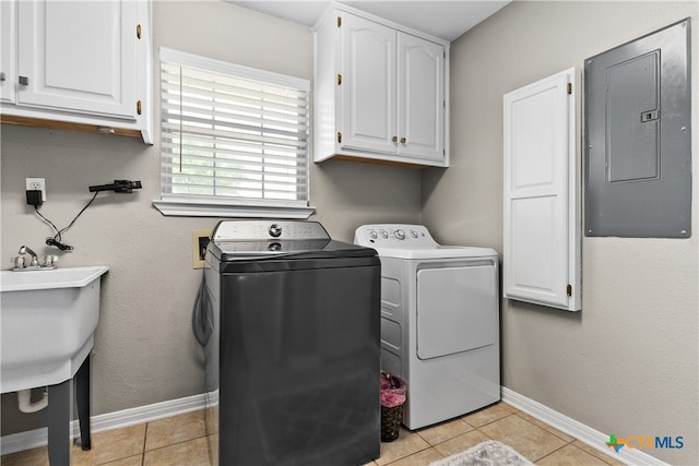 laundry area featuring electric panel, cabinets, washer and dryer, and light tile patterned floors