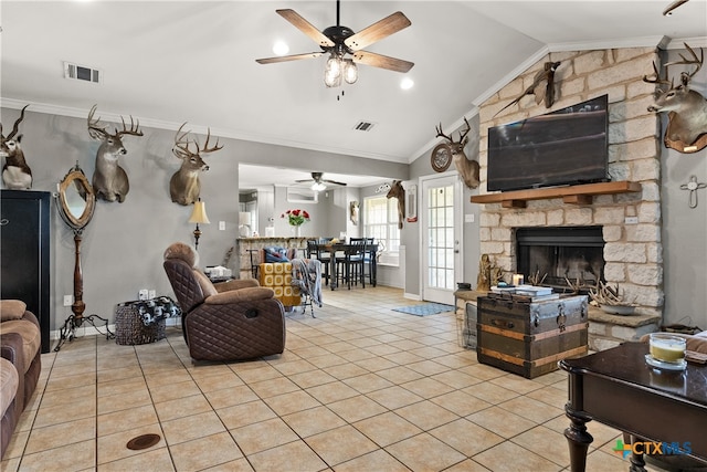 tiled living room with a stone fireplace, lofted ceiling, ceiling fan, and crown molding