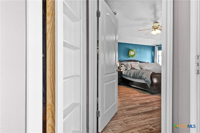 hall featuring hardwood / wood-style floors and a textured ceiling