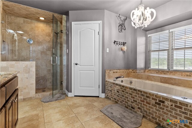 bathroom with a chandelier, vanity, tile patterned flooring, and a shower with shower door