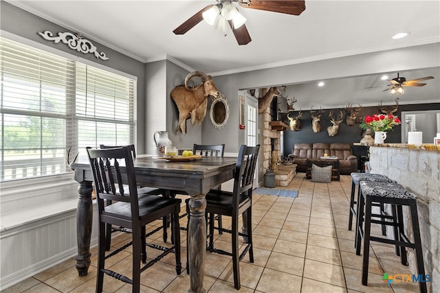 dining room with light tile patterned flooring, crown molding, and ceiling fan