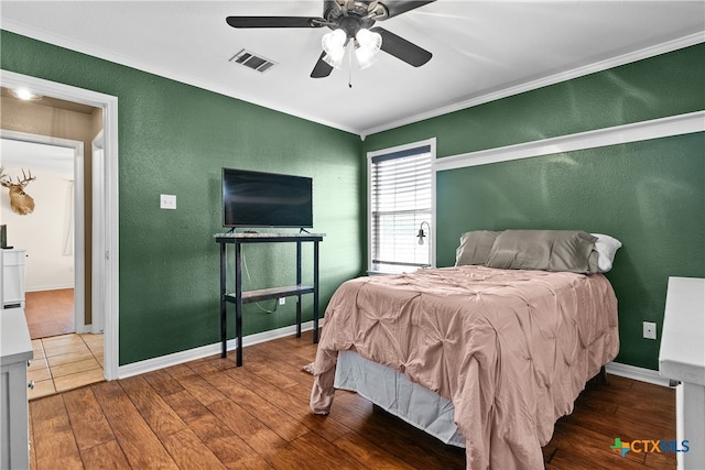 bedroom with ornamental molding, hardwood / wood-style floors, and ceiling fan