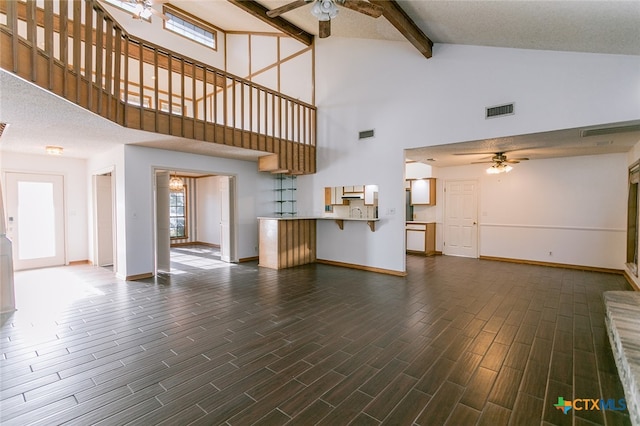 unfurnished living room with a textured ceiling, high vaulted ceiling, dark hardwood / wood-style floors, and ceiling fan