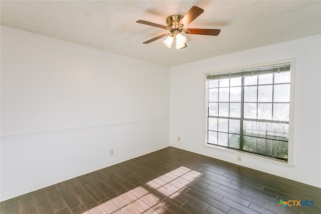 empty room with ceiling fan, a textured ceiling, and dark hardwood / wood-style floors