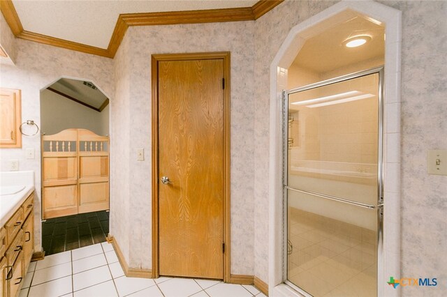 bathroom featuring ornamental molding, tile patterned flooring, walk in shower, and vanity