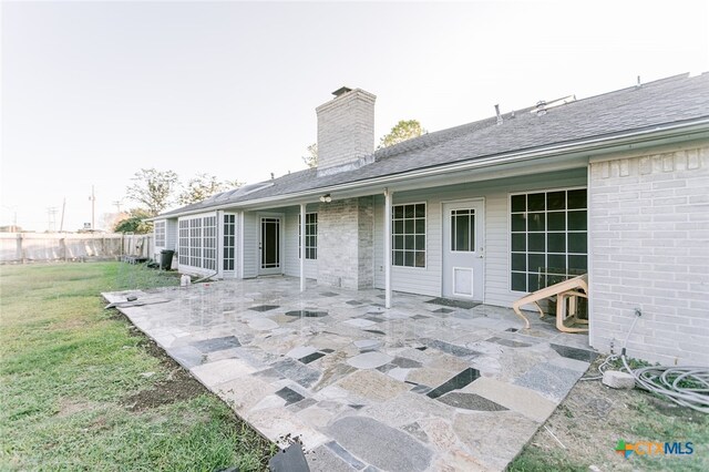 back of house featuring a patio and a lawn