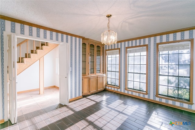 unfurnished dining area with plenty of natural light and a textured ceiling