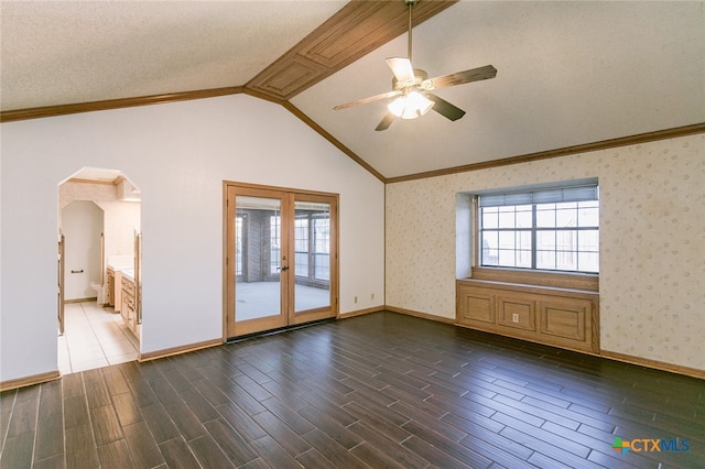 empty room featuring a textured ceiling, dark wood-type flooring, ceiling fan, and vaulted ceiling