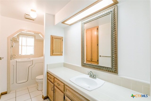 bathroom with tile patterned flooring, a bathtub, vanity, and toilet