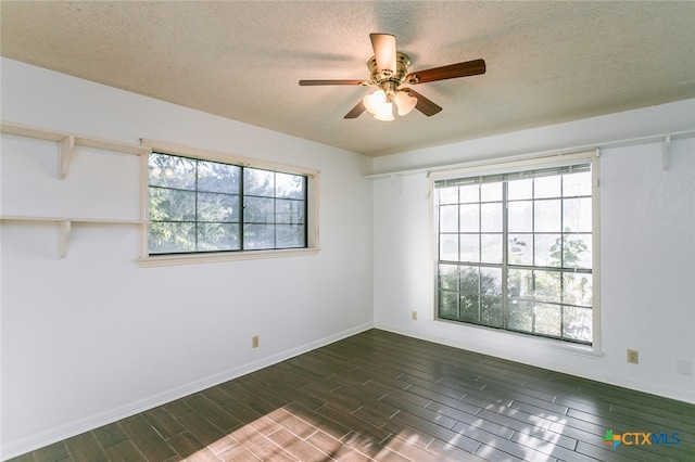 spare room featuring ceiling fan, a wealth of natural light, dark hardwood / wood-style floors, and a textured ceiling