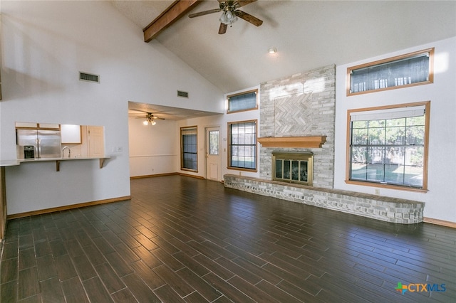 unfurnished living room featuring high vaulted ceiling, dark wood-type flooring, a wealth of natural light, and a fireplace